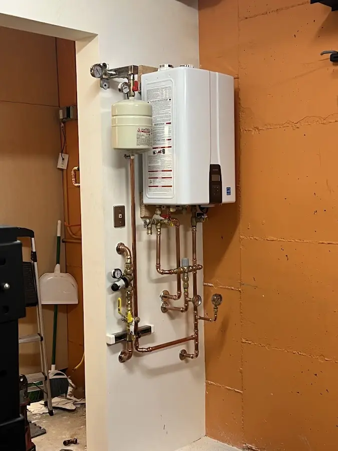 Plumbing technician inspecting water heater connections in Merriam